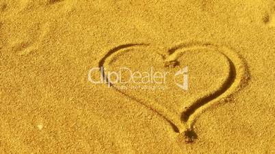 heart on golden sandy beach,wind blow sand.