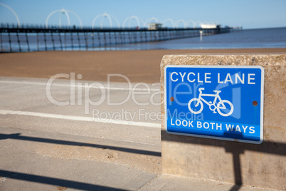 Blue cycle path lane sign by beach