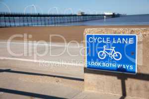 Blue cycle path lane sign by beach
