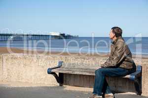 Senior man looking out over beach at Southport