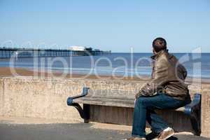 Senior man looking out over beach at Southport