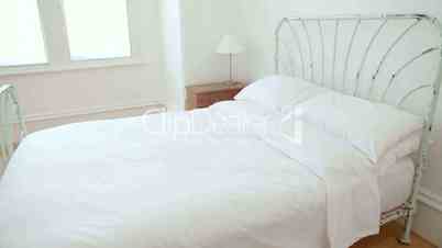 Eisenbett mit weißen Bettbezügen