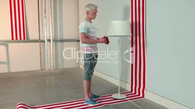 Young man sticking red tape to lampshade