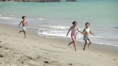 Drei Kinder laufen am Strand entlang