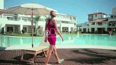 Woman walkling on decking by poolside