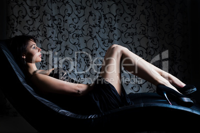 sexy girl in evening dress lying on the sofa
