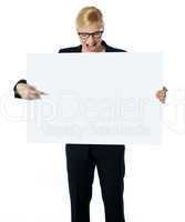 Successful business female pointing at white blank billboard