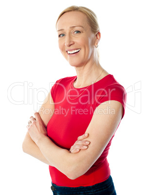 Smiling middle aged lady, poisng with folded arms