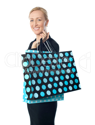 Senior woman posing with dotted shopping bag
