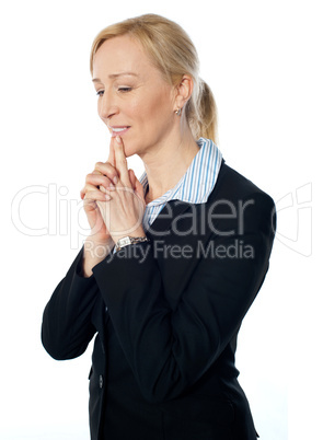 Senior corporate woman posing with fingers on her lips