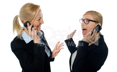 Happy businesswomen communicating on cellphone