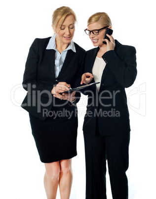 Two females looking at progress report and discussing