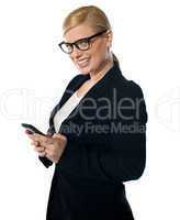 Smiling female business executive messaging