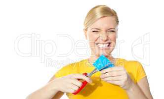 Woman grinding teeth while cutting her credit card