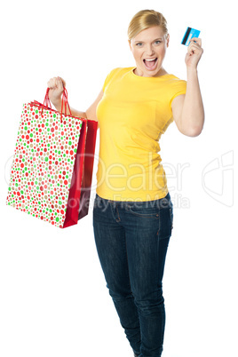 Happy shopaholic girl showing credit card