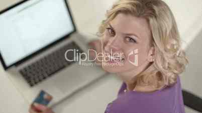 E-commerce, young woman paying by credit card with laptop computer