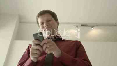 Young man typing sms on smartphone and smiling