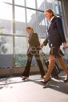 two businesswomen with trolley