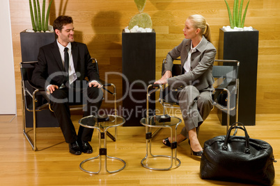 business man and business woman waiting in office lobby