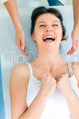 young caucasian woman lying down smiling and receiving head mass