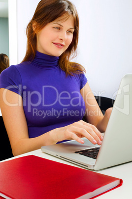 portrait of a young caucasian woman in office with laptop