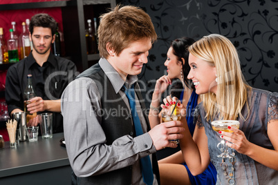 Happy friends at cocktail bar enjoy drinks