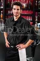 Professional barman in black standing bar