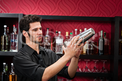 Young bartender make cocktail shaking drinks