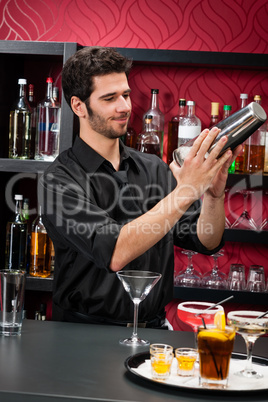 Young bartender make cocktail shaking drinks