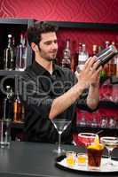 Young bartender make cocktail shaking drinks