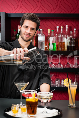 Young bartender make cocktail shaking drinks