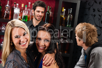 Girl friends at the bar hugging together