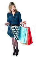 Fashionable woman looking into shopping bags