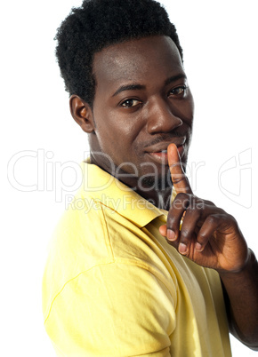 Handsome young guy gesturing silence