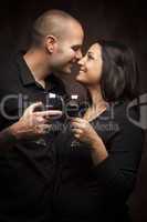 Happy Mixed Race Couple Flirting and Holding Wine Glasses