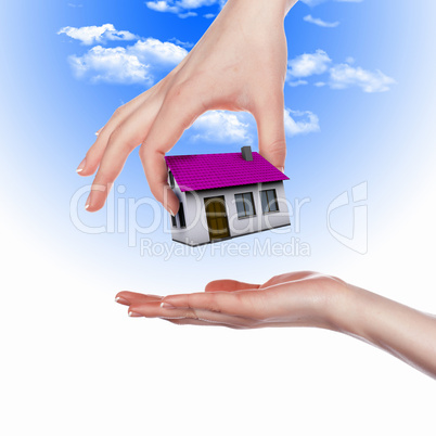 House and human hand against blue sky