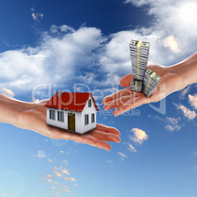 House and human hand against blue sky