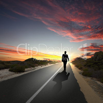 Man walking away at dawn along road