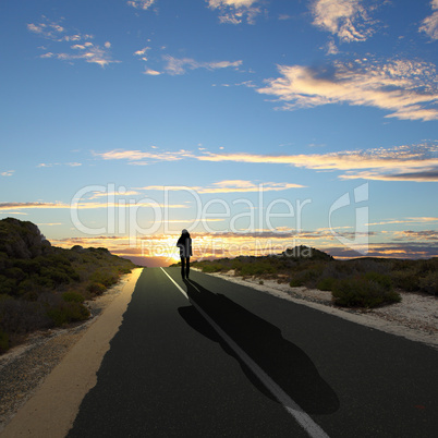 Man walking away at dawn along road