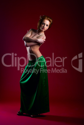 Beauty woman posing on red in green dress