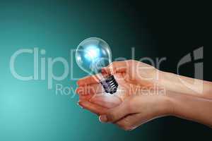 Human hand holding electric bulb