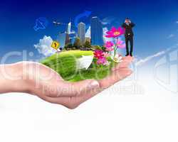 human hand holding a green city