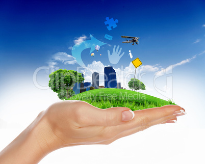 human hand holding a green city