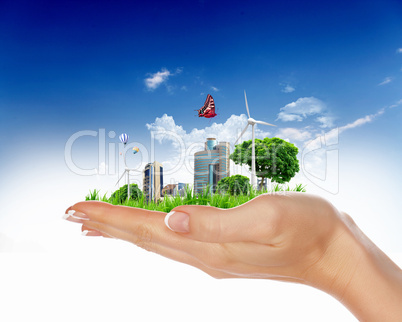 human hand holding a green city