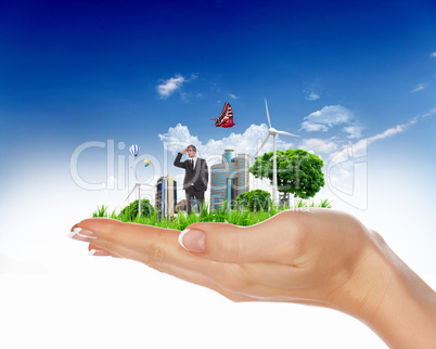 human hand holding a green city