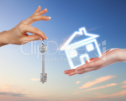 Human hands and house against blue sky