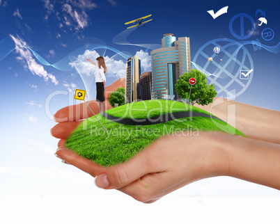human hand holding a green city