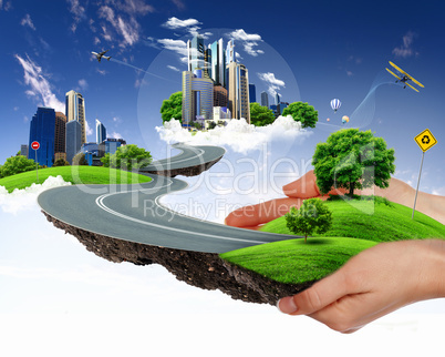 human hand holding a green city