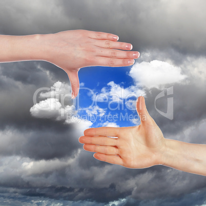 Hands and blue cloudy sky