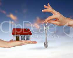 Human hands and house against blue sky